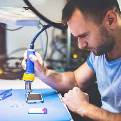 expert man repairing smartphone at workplace